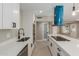 Modern kitchen featuring quartz counters, stainless appliances, and unique blue vent hood and island at 3538 W Sierra Vista Dr, Phoenix, AZ 85019