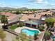Aerial view of the backyard with pool, covered patio and mature landscaping and palm trees at 4002 N San Gabriel Cir, Mesa, AZ 85215