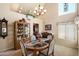 Dining room with large windows and a decorative chandelier is furnished with china cabinet and piano along one wall at 4002 N San Gabriel Cir, Mesa, AZ 85215