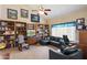 Living room with vaulted ceilings and many windows that bring in light and illuminate the bookcases and comfortable furniture at 4002 N San Gabriel Cir, Mesa, AZ 85215