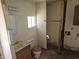 An incomplete bathroom with a toilet, sink, and a single window ready to be renovated at 4110 E Wagoner Rd, Phoenix, AZ 85032