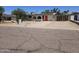 Street view of a single-story home with desert landscaping and a bright red front door at 4110 E Wagoner Rd, Phoenix, AZ 85032