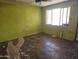 Unfinished living room featuring bright green walls, a ceiling fan, and an open window at 4110 E Wagoner Rd, Phoenix, AZ 85032