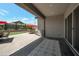 Spacious covered back patio with patterned flooring, a cozy outdoor seating area, and lush landscaping at 41215 W Almira Dr, Maricopa, AZ 85138