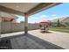 Backyard patio with pavers, a red umbrella, outdoor furniture, and a well-kept artificial grass area at 41215 W Almira Dr, Maricopa, AZ 85138