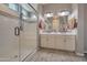 A well-appointed bathroom with double sinks, a glass shower, and a modern and sleek design at 41215 W Almira Dr, Maricopa, AZ 85138