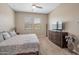 Bright bedroom with a large window, ceiling fan, TV, and dresser, all contributing to a comfortable atmosphere at 41215 W Almira Dr, Maricopa, AZ 85138