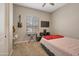 Cozy bedroom with carpeted floors, a window, and a comfortable bed with red accents at 41215 W Almira Dr, Maricopa, AZ 85138