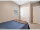 Cozy bedroom featuring a window with blinds, a closet, and a complementary door, creating a comfortable ambiance at 41215 W Almira Dr, Maricopa, AZ 85138