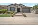 Charming home featuring a stone facade, paved driveway, and well-maintained landscaping at 41215 W Almira Dr, Maricopa, AZ 85138