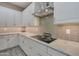 Bright kitchen showing stainless steel range hood and cooktop at 41215 W Almira Dr, Maricopa, AZ 85138