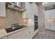 Bright kitchen showing stainless steel range hood, cooktop, microwave, and oven at 41215 W Almira Dr, Maricopa, AZ 85138