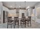 Bright kitchen features an island with seating, pendant lighting, stainless steel appliances, and white cabinetry at 41215 W Almira Dr, Maricopa, AZ 85138