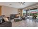Spacious living room boasts a ceiling fan, sliding glass doors to the backyard, and a leather sofa set at 41215 W Almira Dr, Maricopa, AZ 85138