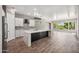 Open-concept kitchen with a large island, white cabinets, and view to living area with bright natural light at 422 E Kaibab Pl, Chandler, AZ 85249