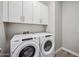 Well-lit laundry room featuring a modern washer and dryer with overhead cabinets at 422 E Kaibab Pl, Chandler, AZ 85249