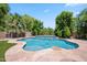 Beautiful private pool with stone decking, lush greenery, and cascading water features offers a serene outdoor oasis at 422 E Kaibab Pl, Chandler, AZ 85249