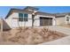 Charming single-Gathering home featuring a two-car garage, desert landscaping, and a modern blue front door at 5566 S 254Th Gln, Buckeye, AZ 85326
