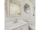 Bright bathroom featuring a white vanity, framed mirror, round mirror, toilet, and shower at 5649 W Holly St, Phoenix, AZ 85035