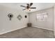 Cozy bedroom with carpet, ceiling fan, and window with natural light at 5649 W Holly St, Phoenix, AZ 85035