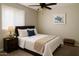 Comfortable bedroom with a ceiling fan, bedside table, and stylish decor at 5649 W Holly St, Phoenix, AZ 85035
