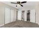 Bedroom with carpeted floor, ceiling fan, and closet; bathroom through ensuite at 5649 W Holly St, Phoenix, AZ 85035