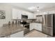Updated kitchen with granite countertops, stainless steel appliances, and white cabinets at 5649 W Holly St, Phoenix, AZ 85035