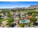 Aerial view of the community featuring lush green landscaping, tennis courts, pool, and mountain views at 6138 N 28Th St, Phoenix, AZ 85016