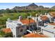 Aerial view of the white condo with red tile roof against golf course and mountain backdrop at 6138 N 28Th St, Phoenix, AZ 85016