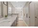 Bright bathroom with double sinks, quartz counters, and a glass-enclosed walk-in shower featuring stylish marble tile at 6138 N 28Th St, Phoenix, AZ 85016