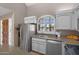 Galley kitchen with stainless steel appliances, grey cabinets and countertops, and a window above the sink at 6138 N 28Th St, Phoenix, AZ 85016