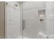 Modern tiled shower features glass door, rainfall shower head, and built-in shelf for toiletries at 6138 N 28Th St, Phoenix, AZ 85016