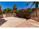 Private backyard featuring a concrete patio, beautiful bougainvillea, and block wall fencing at 6439 E Redmont Dr, Mesa, AZ 85215
