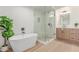 Bright bathroom with soaking tub, glass shower, wood cabinets, and modern fixtures at 6439 E Redmont Dr, Mesa, AZ 85215