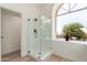 Bathroom featuring a stand-up glass shower, arched window, and natural light at 6439 E Redmont Dr, Mesa, AZ 85215