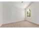 Bright bedroom features a vaulted ceiling, carpet, and a charming arched window at 6439 E Redmont Dr, Mesa, AZ 85215