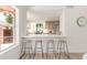 Breakfast bar with stools overlooks the kitchen and dining area at 6439 E Redmont Dr, Mesa, AZ 85215