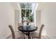 Dining nook with skylight has a black table and four upholstered chairs at 6439 E Redmont Dr, Mesa, AZ 85215