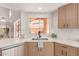 Bright kitchen featuring a stainless steel sink, natural wood cabinetry, and bright countertops at 6439 E Redmont Dr, Mesa, AZ 85215