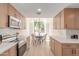Bright kitchen with stainless appliances, white counters, light wood cabinets, and dining nook at 6439 E Redmont Dr, Mesa, AZ 85215