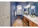 Bathroom with double sinks, wood cabinets, and archway that peeks into bedroom at 776 W Carob Way, Chandler, AZ 85248