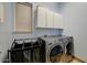 Laundry room equipped with modern washer and dryer, white cabinets, and storage at 776 W Carob Way, Chandler, AZ 85248