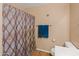 Bathroom featuring shower with patterned curtain, wood-look floors and blue towels at 8259 W Carol Ave, Peoria, AZ 85345