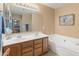Bathroom featuring double sinks, a large mirror and soaking tub at 8259 W Carol Ave, Peoria, AZ 85345