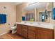 Bathroom featuring a dual sink vanity with wood cabinets and framed mirror at 8259 W Carol Ave, Peoria, AZ 85345