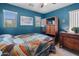 Bedroom featuring a blue accent wall, a ceiling fan and matching dresser at 8259 W Carol Ave, Peoria, AZ 85345