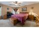 Comfortable bedroom with a ceiling fan, a desk and a wooden chest at the end of the bed at 8259 W Carol Ave, Peoria, AZ 85345