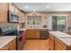 Well-lit kitchen with stainless steel dishwasher and oven, wood cabinets and laminate countertops at 8259 W Carol Ave, Peoria, AZ 85345