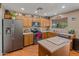 Bright kitchen features stainless steel appliances, wood cabinets, and a center island at 8259 W Carol Ave, Peoria, AZ 85345
