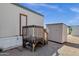 An exterior shot features a wooden deck and shed set against a blue sky and gravel yard at 8421 E Main St # 116, Mesa, AZ 85207